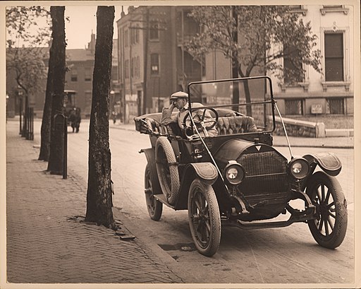 Man_seated_in_automobile_on_unidentified_street